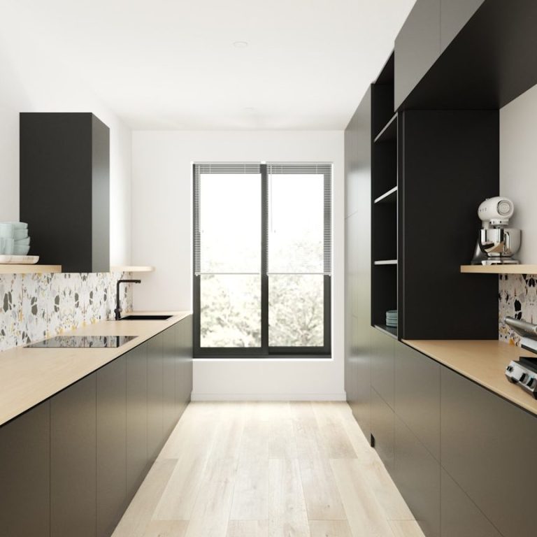 Cocina moderna con armarios negros, encimera de madera y ventana amplia.